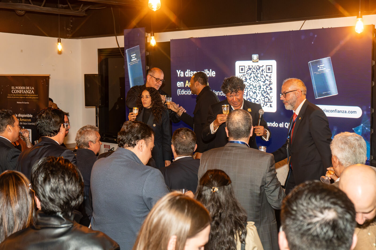 Moisés D. Garvin con su libro y el pastel de lanzamiento
